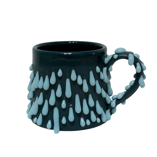 Dark teal green mug with light blue glaze gloops